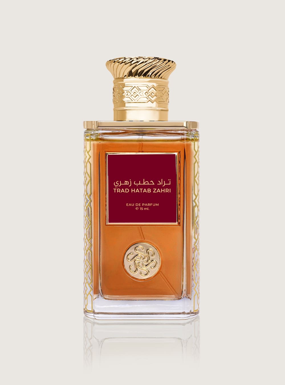 زجاجة عطر تراد الحطب الزهري من سكة الطيب، بسائل كهرماني وملصق أحمر داكن وغطاء ذهبي مزخرف، على خلفية فاتحة.