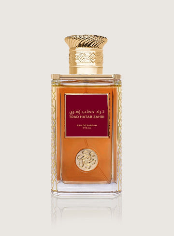 زجاجة عطر تراد الحطب الزهري من سكة الطيب، بسائل كهرماني وملصق أحمر داكن وغطاء ذهبي مزخرف، على خلفية فاتحة.